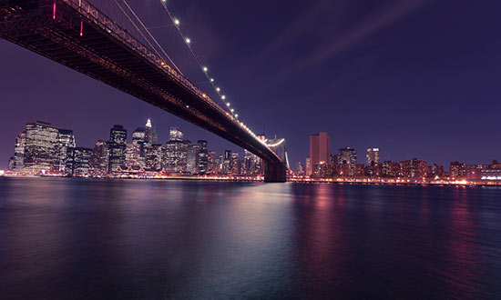 En bro i New York som är vackert upplyst under kvällen