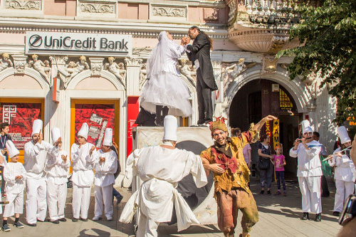 Gatufestival i Rumänien med människor som dansar i vita eller färgglada dräkter