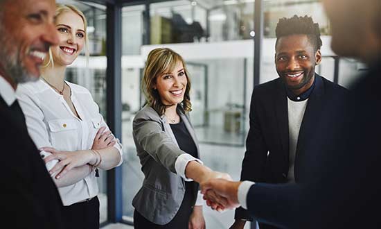 Kvinna på affärsbesök som skakar hand med de som tagit emot henne