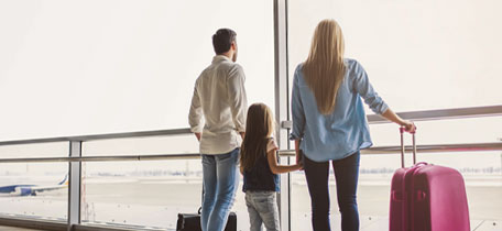 Familj på flygplats med resväskor