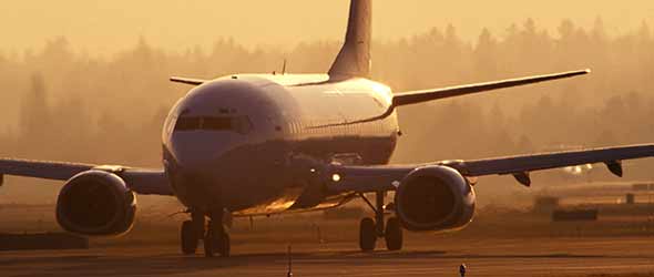 Ett flygplan på startbanan i soluppgången. 