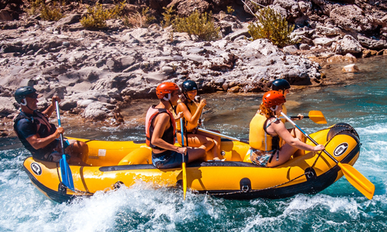 Fem personer i gul gummibåt som utför forsränning